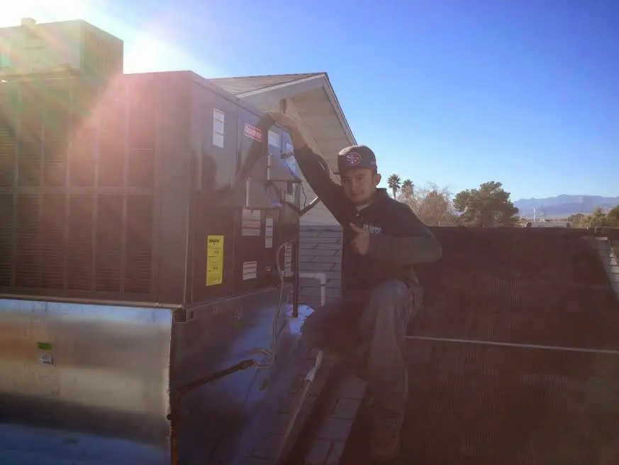 HVAC technician performing Air Duct Repair on a rooftop unit in French Valley